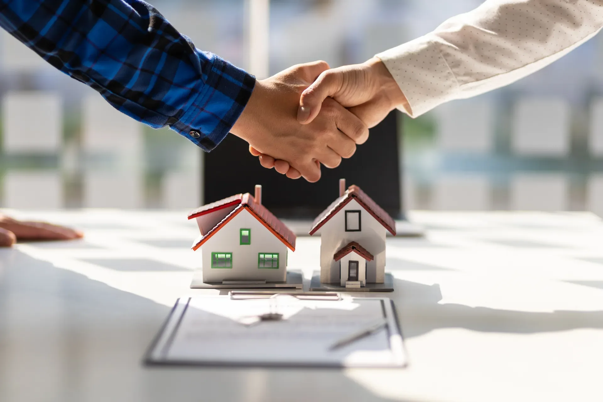 Two colleagues over agreement paperwork — each member site carries its own signatures