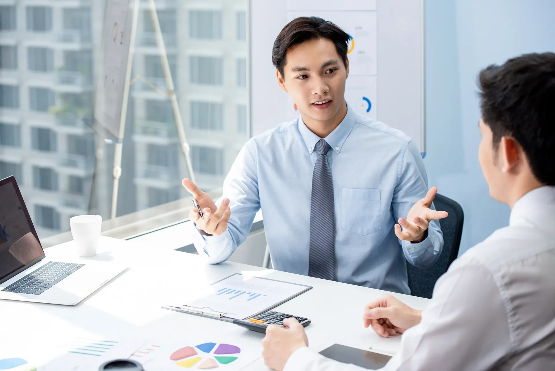 An agent walking clients through figures on a screen — the listing presentation is a demonstration, not a speech