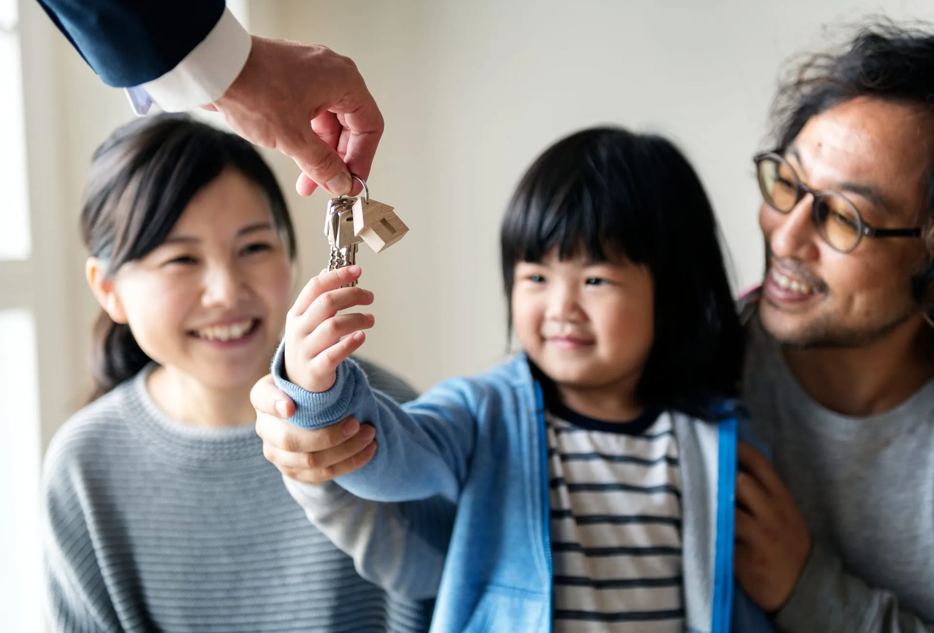 An agent with a young family in front of a home — the family-mover demand a Surrey pipeline is built on