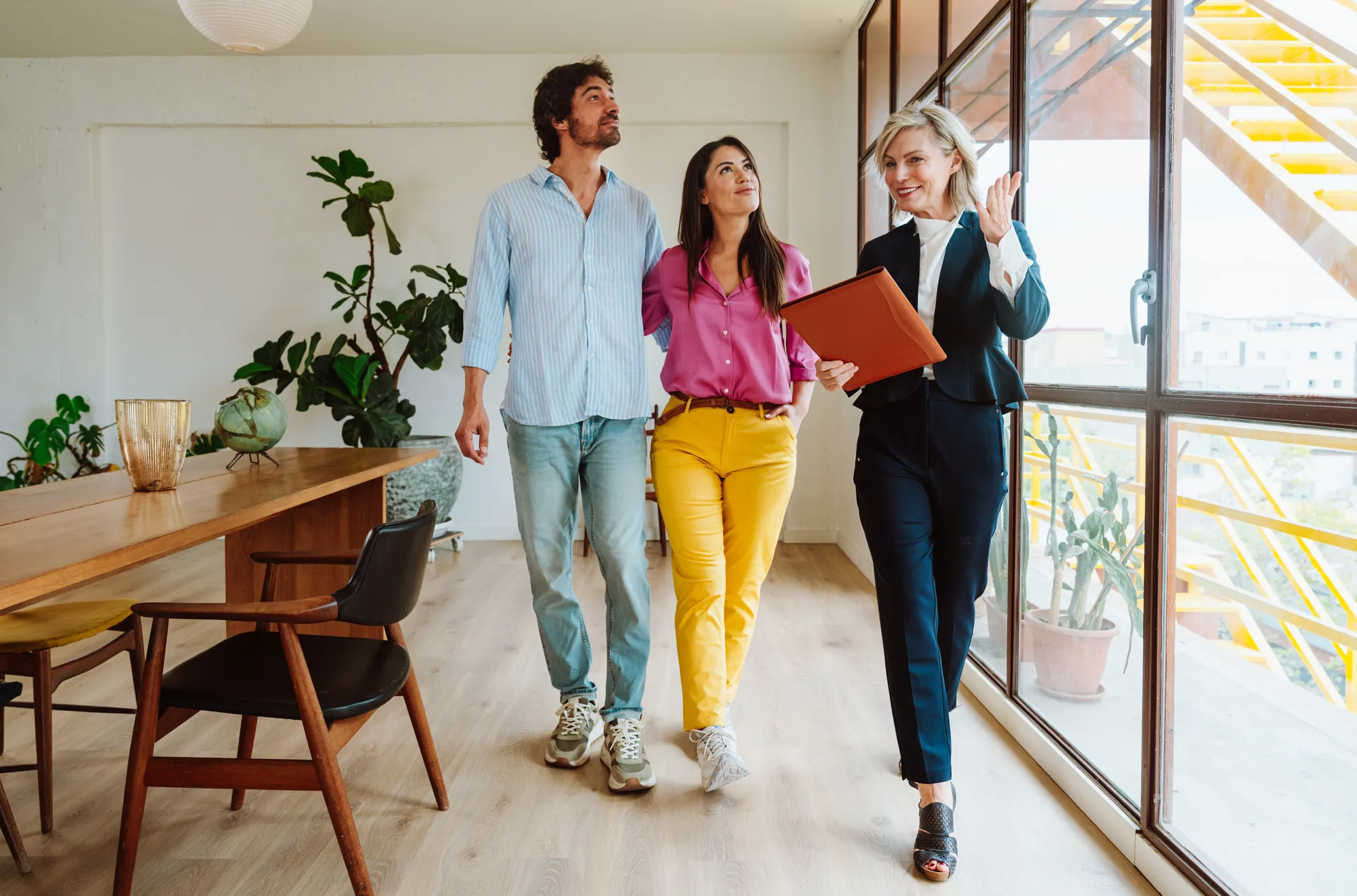 An agent showing a bright apartment to a prospective tenant — the rental lane where university-town pipelines begin
