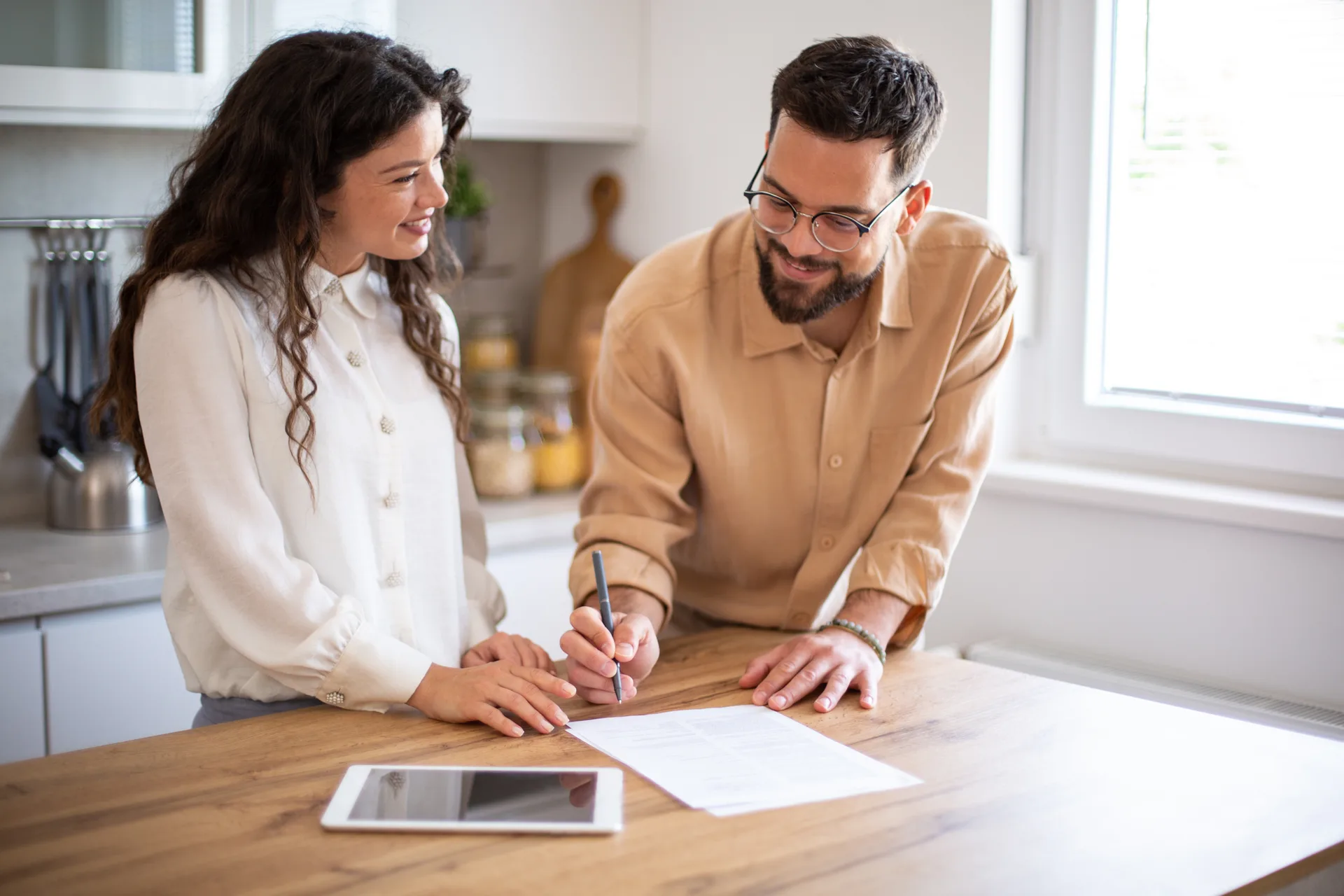 Homeowners working through paperwork at their kitchen table