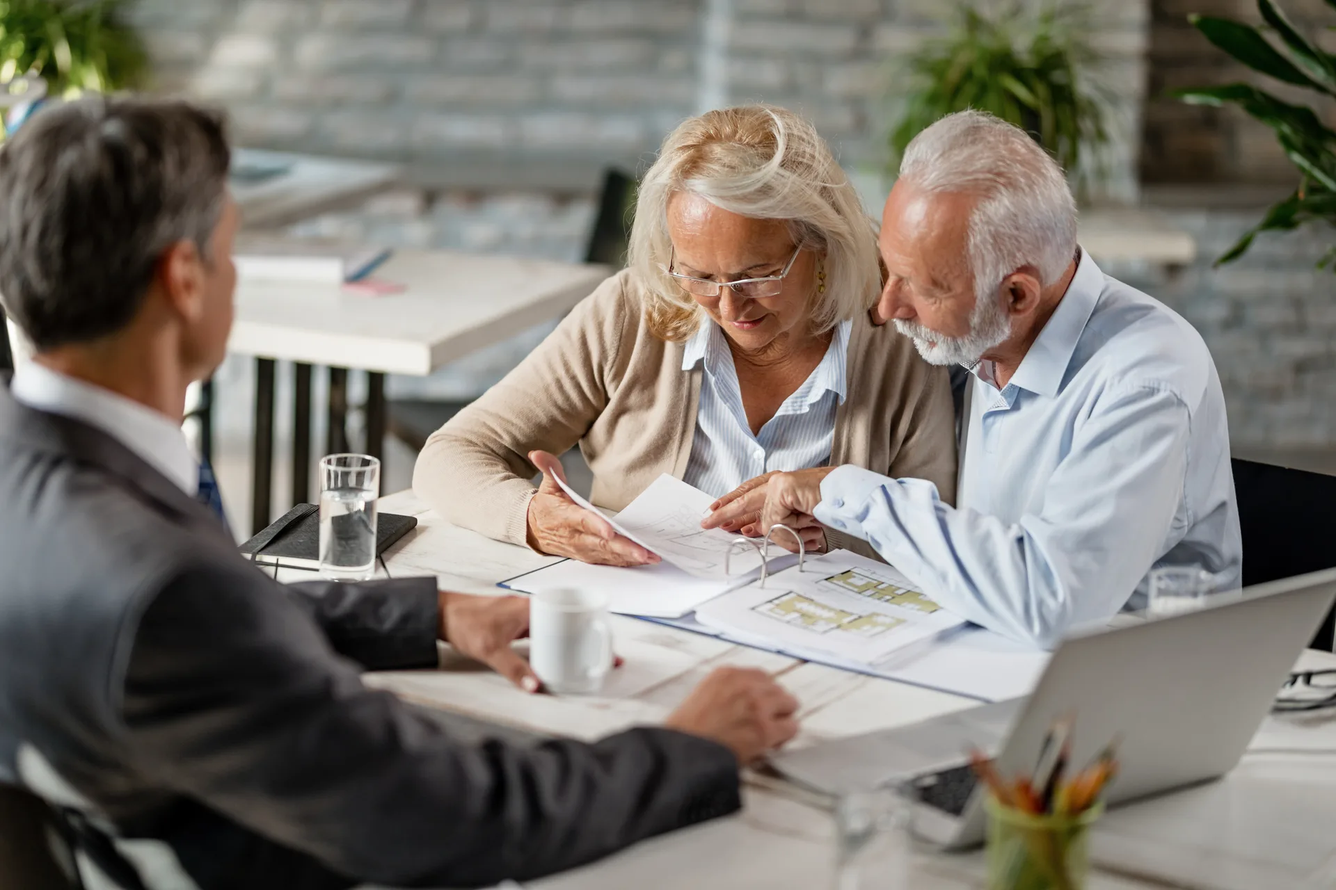 An agent meeting long-time clients at their kitchen table — the relationships a sphere database exists to keep warm