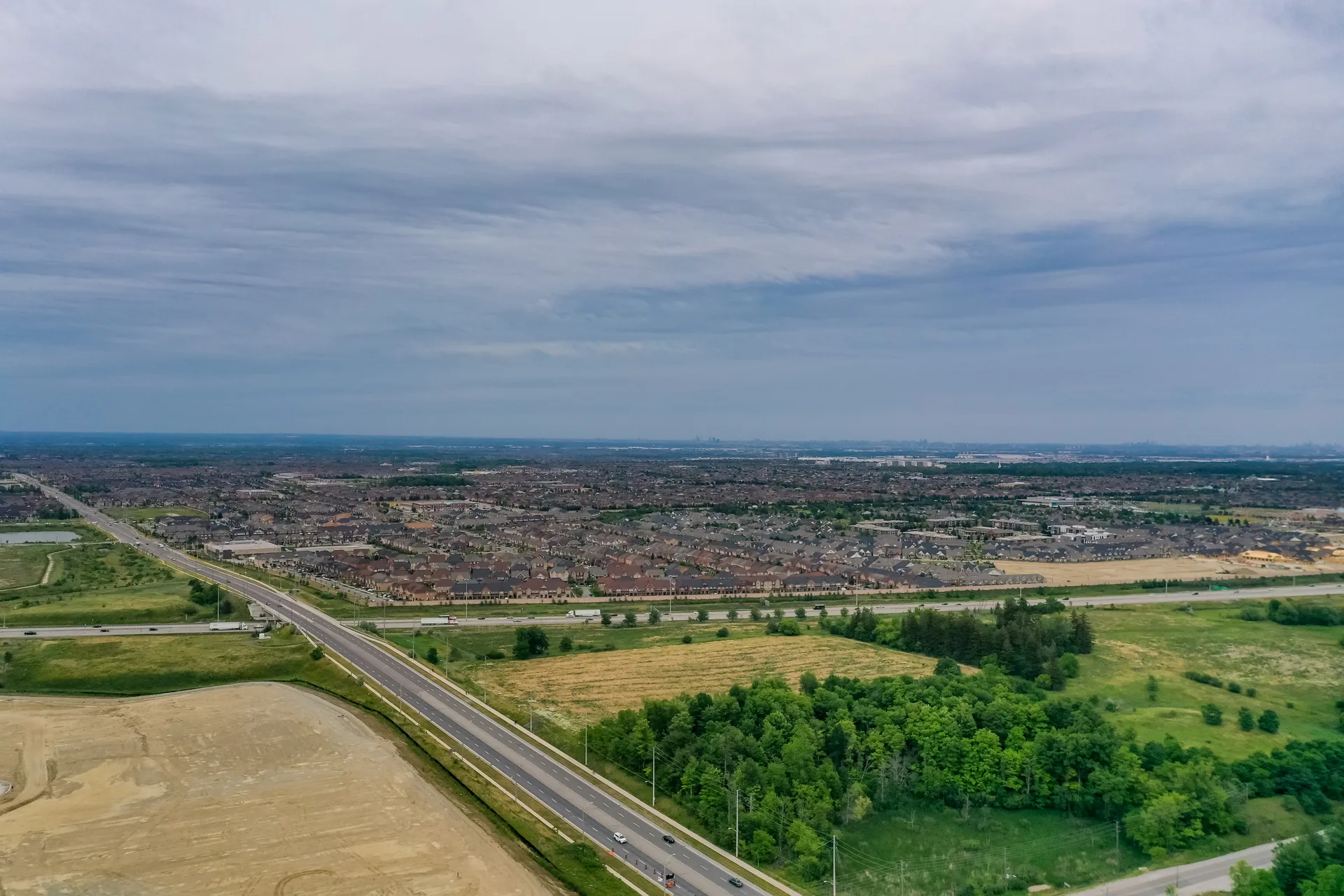 Heart Lake Conservation Park at dusk with Brampton's subdivisions at its edge — growth pressing against green