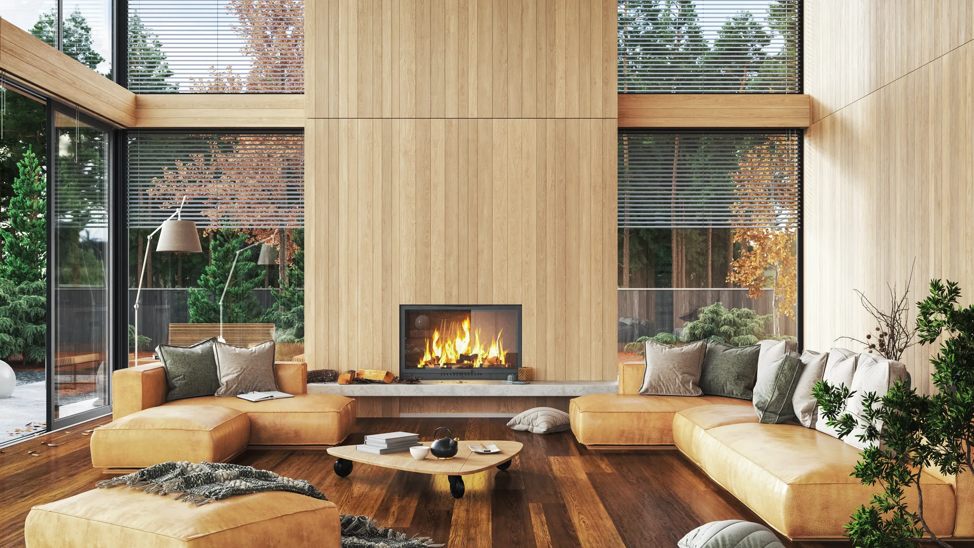 A modern living room with a fireplace and forest views — the four-season retreat aesthetic buyers come looking for