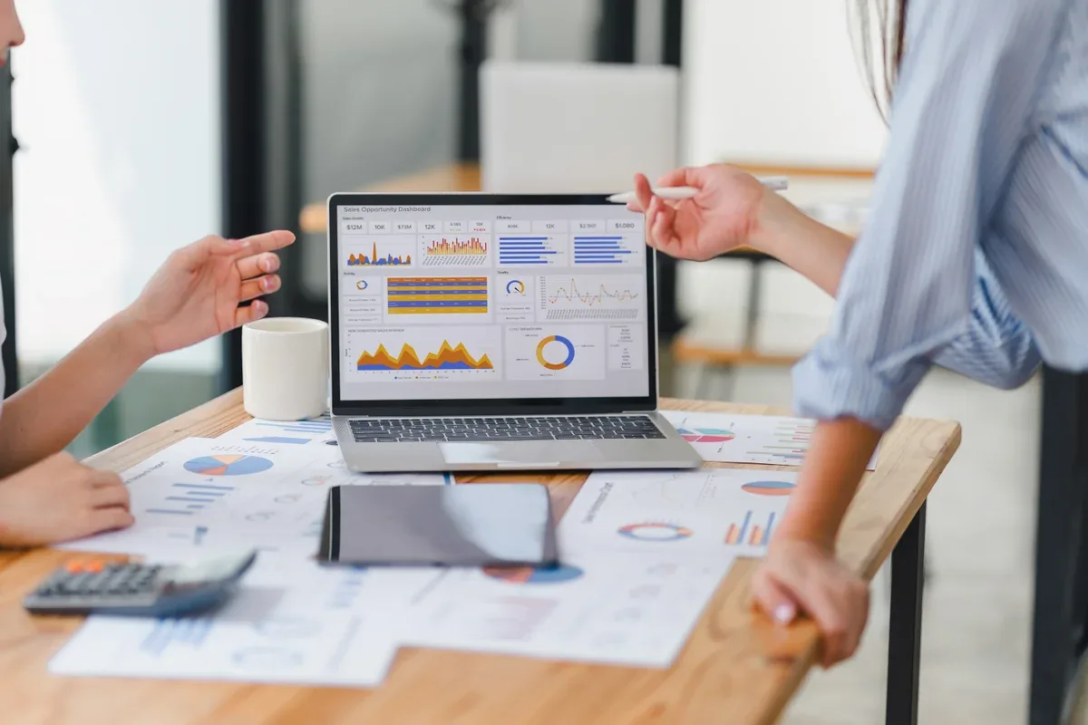 Two analysts reading a performance dashboard — Canadian real estate SEO is measurable work, not a retainer mystery