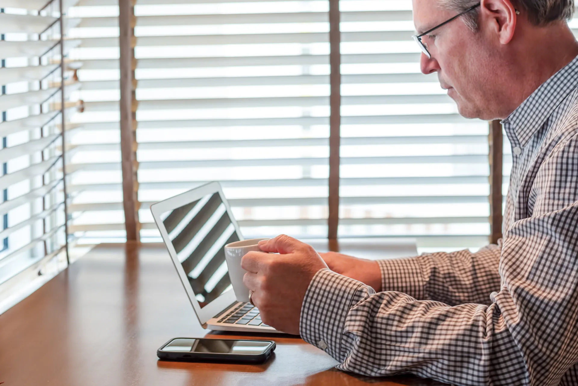 An agent working through new inquiries on a laptop at an office desk