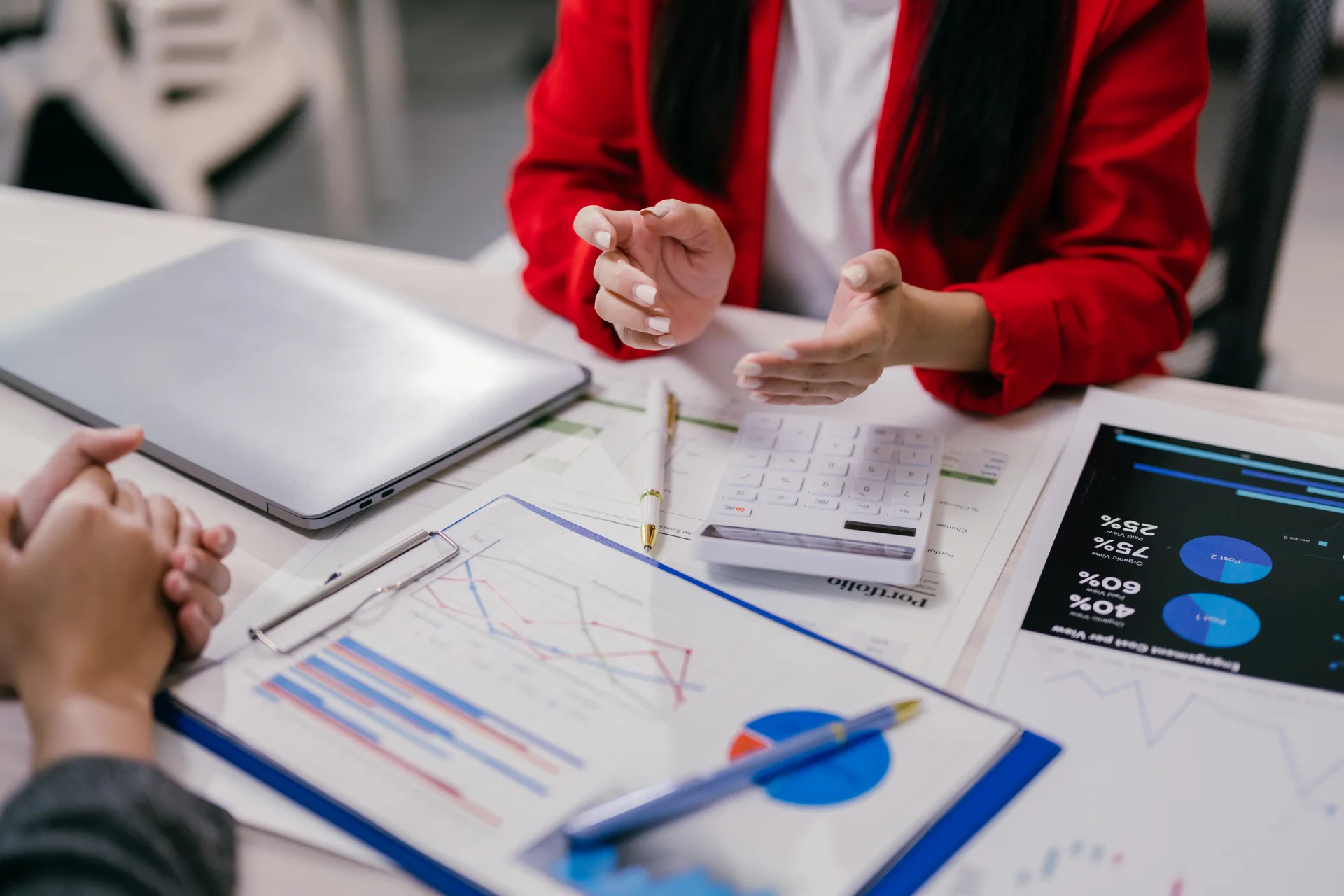 A manager walking a client through campaign charts — reporting on outcomes is the recurring deliverable of PPC management
