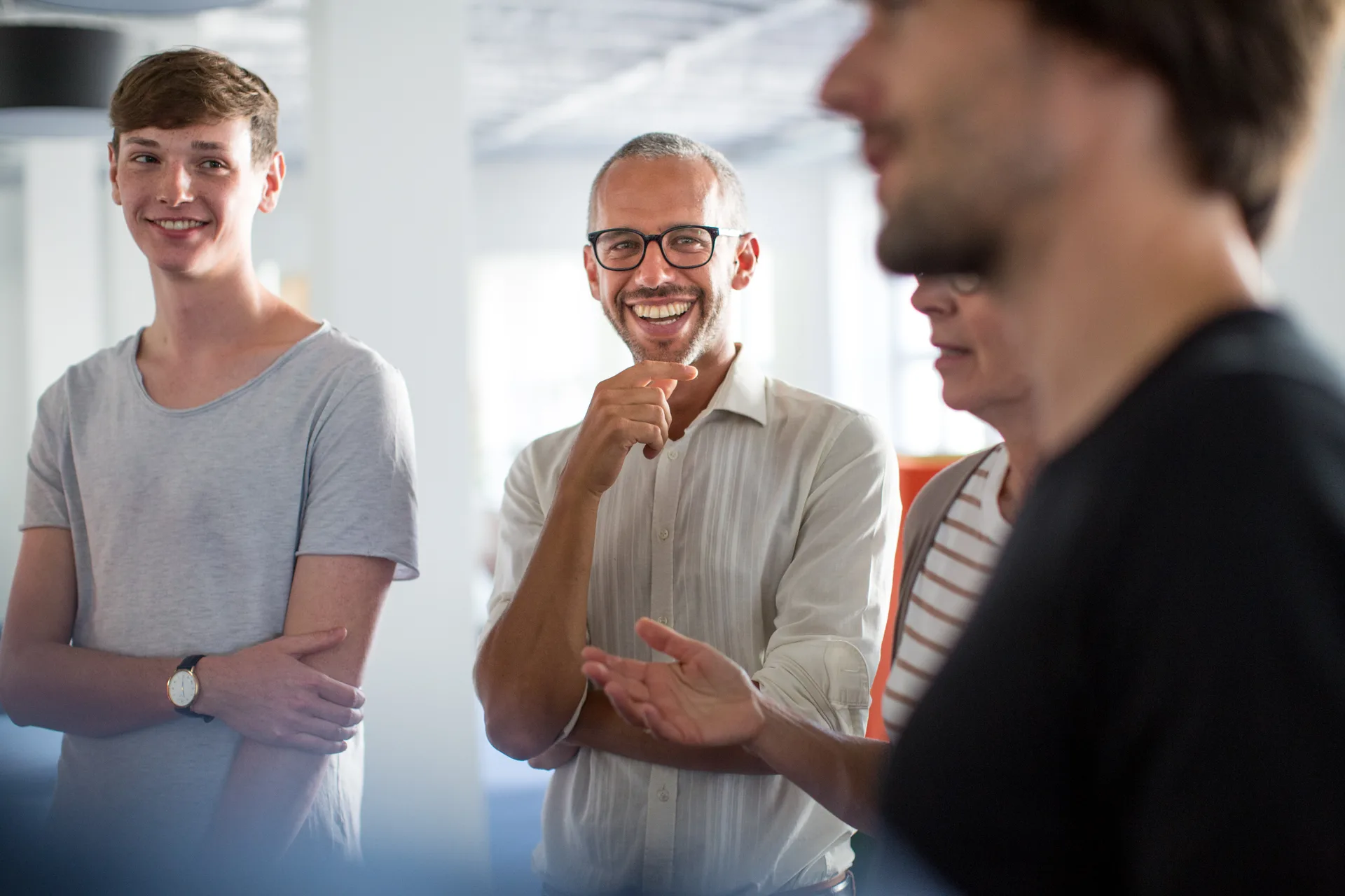 A small team reviewing work together around a standing meeting