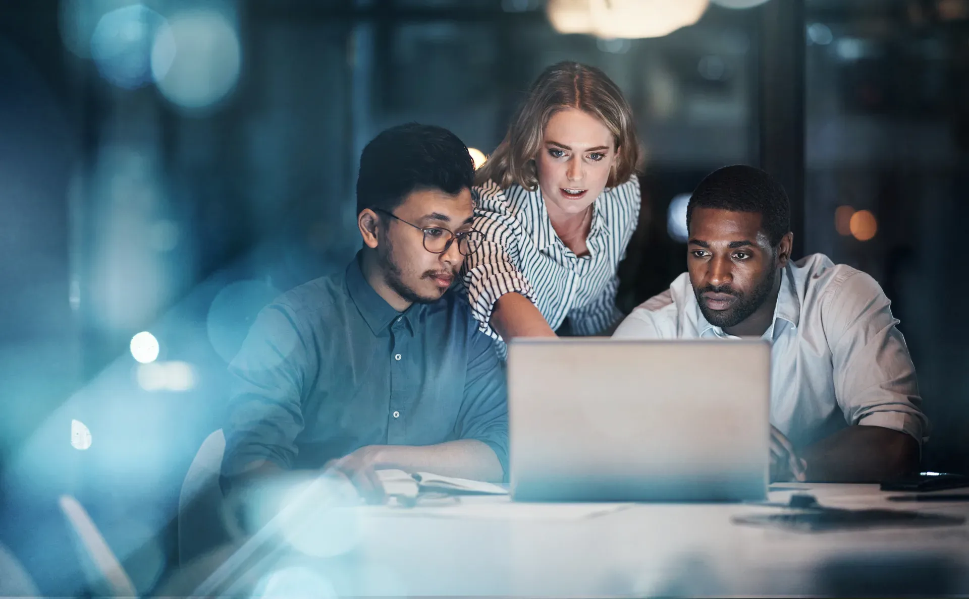 A small team working late at one laptop — running a TRREB feed is an operations commitment, not an install step