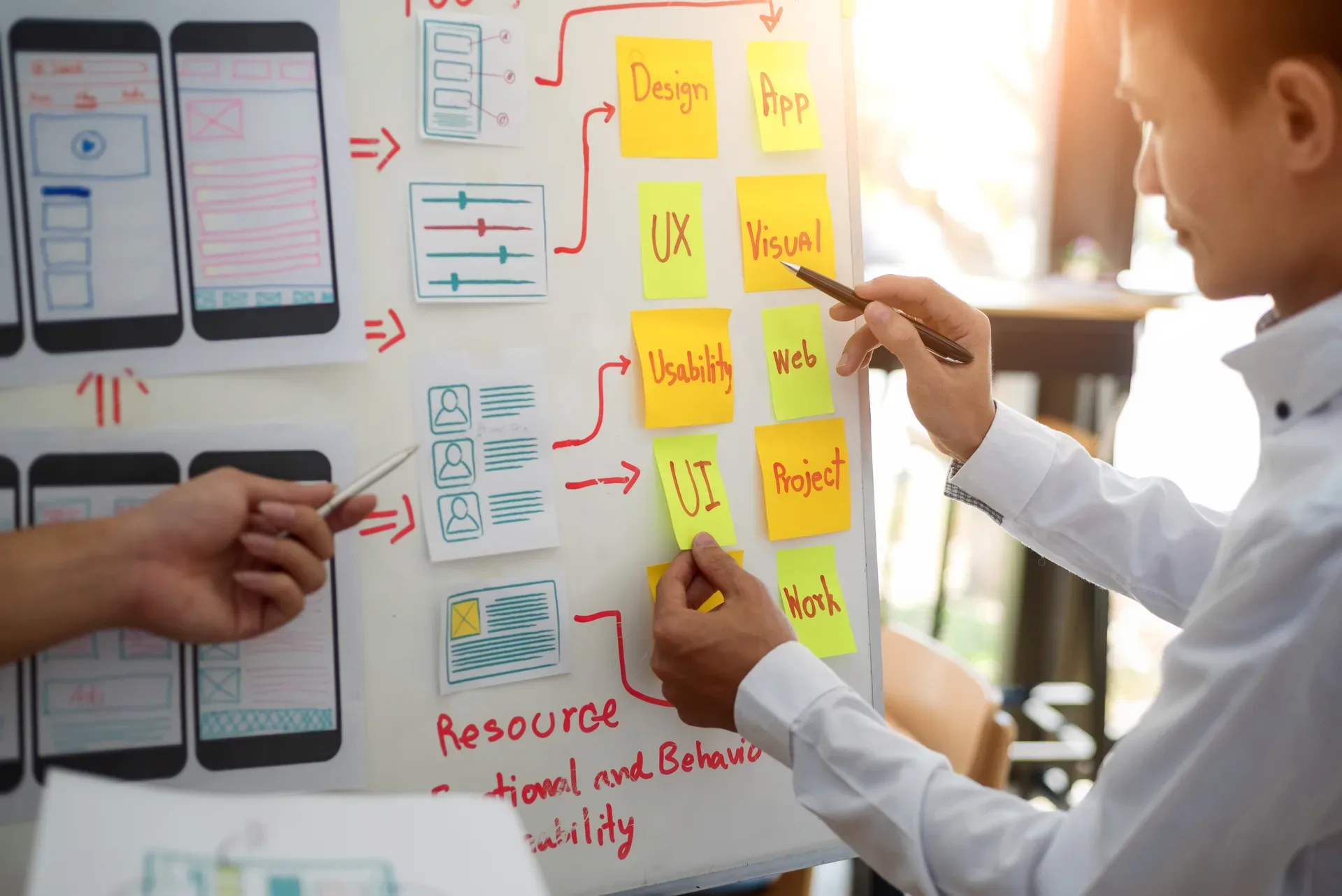 Designers reviewing page layouts together — studying the patterns that make real estate sites convert