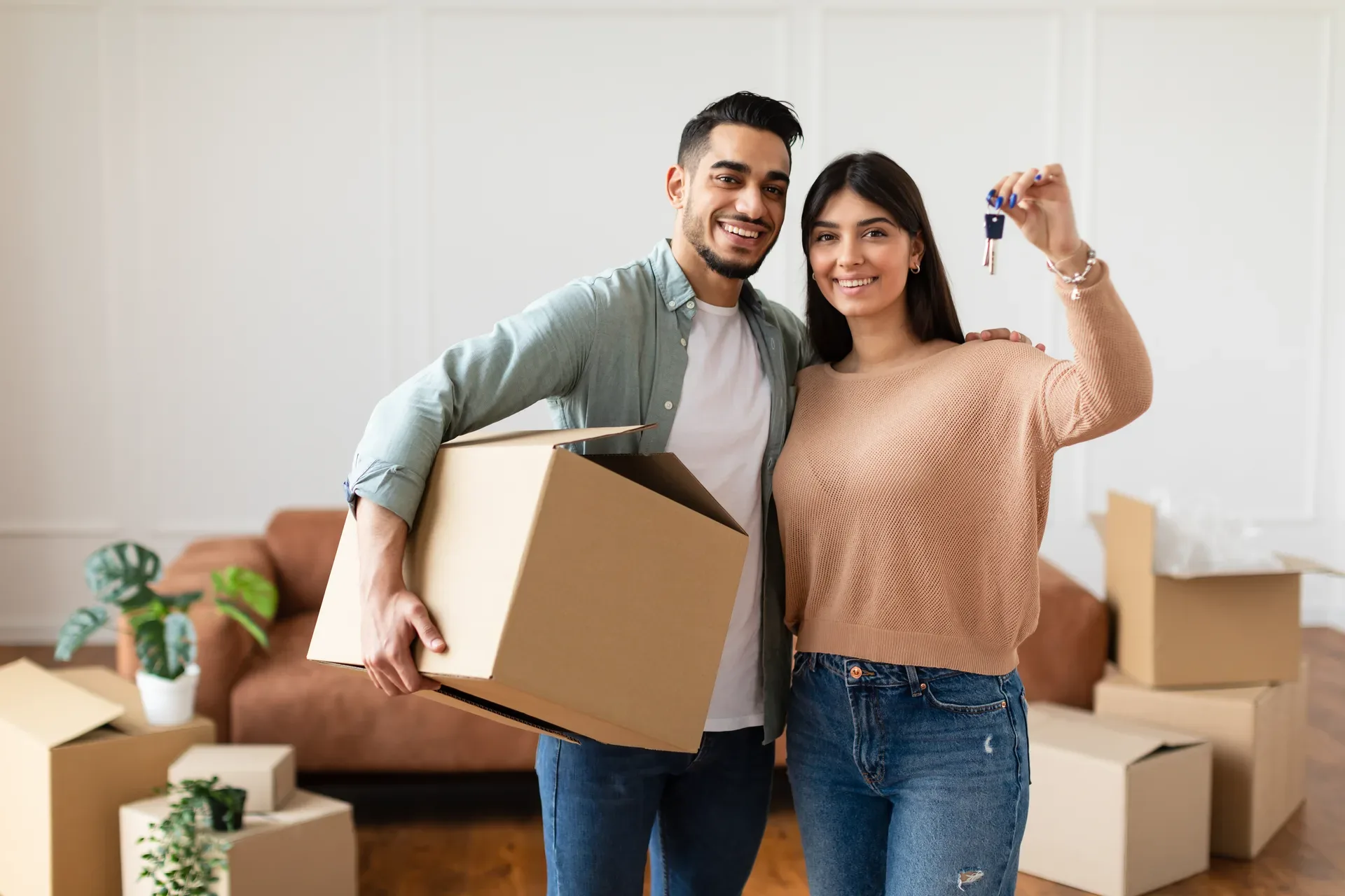 A young couple with the keys to their first apartment — the rental entry point where Markham's future buyers first become contacts