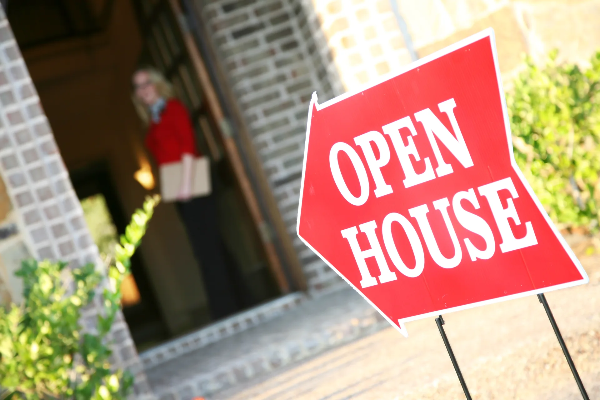 An agent welcoming visitors at the door during an open house