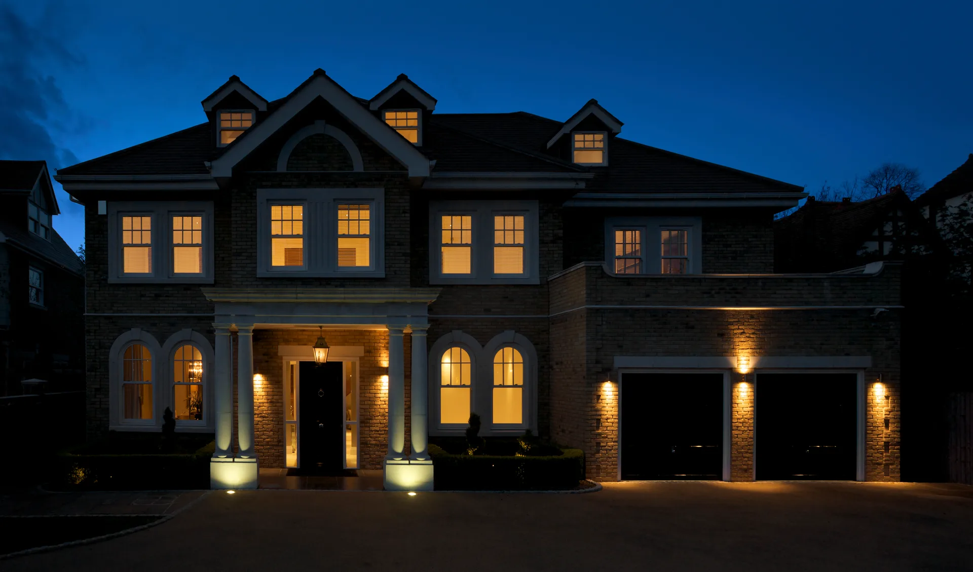 A grand home under evening light — the premium presentation segment both vendors court